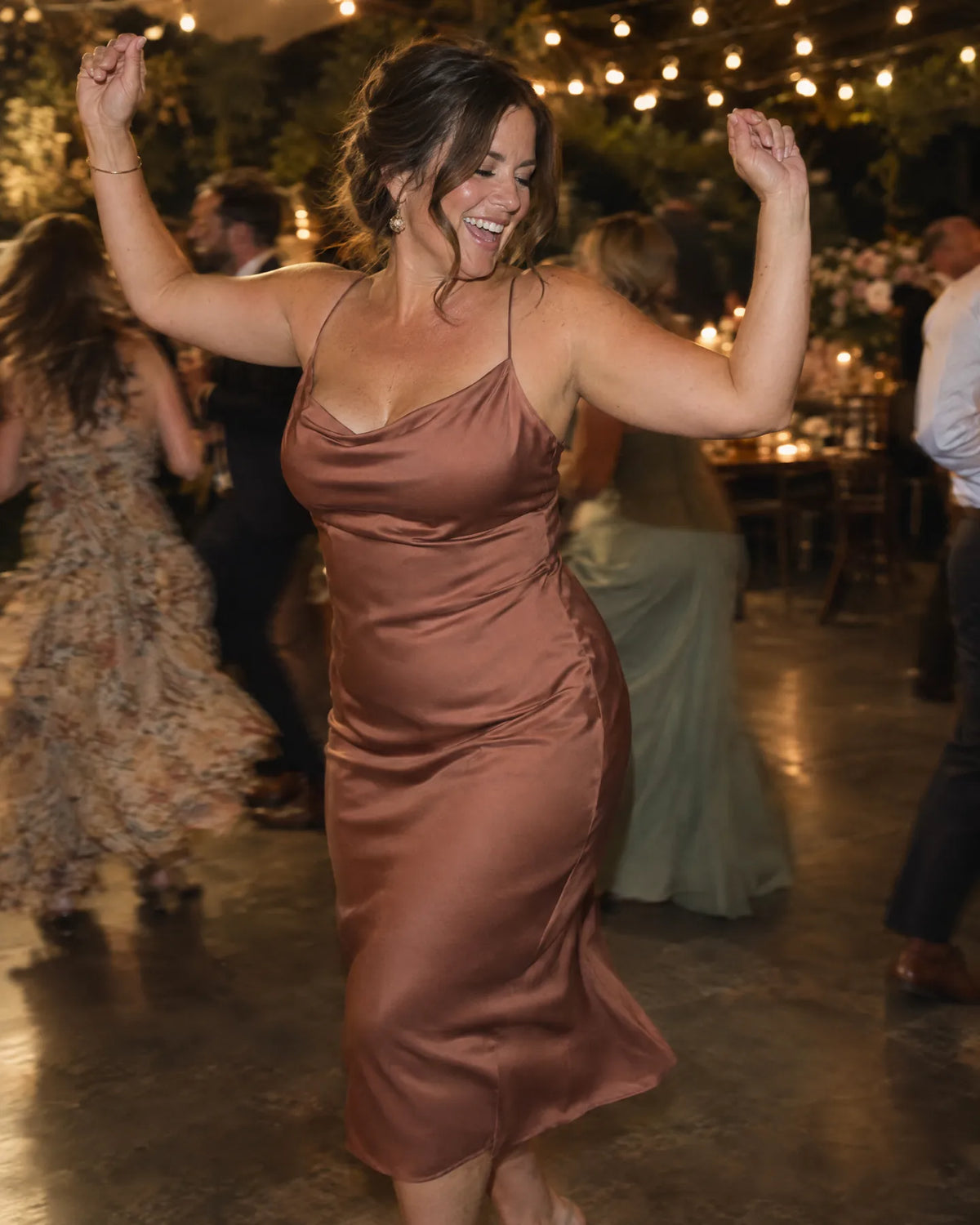 Woman dancing at a wedding in a satin dress